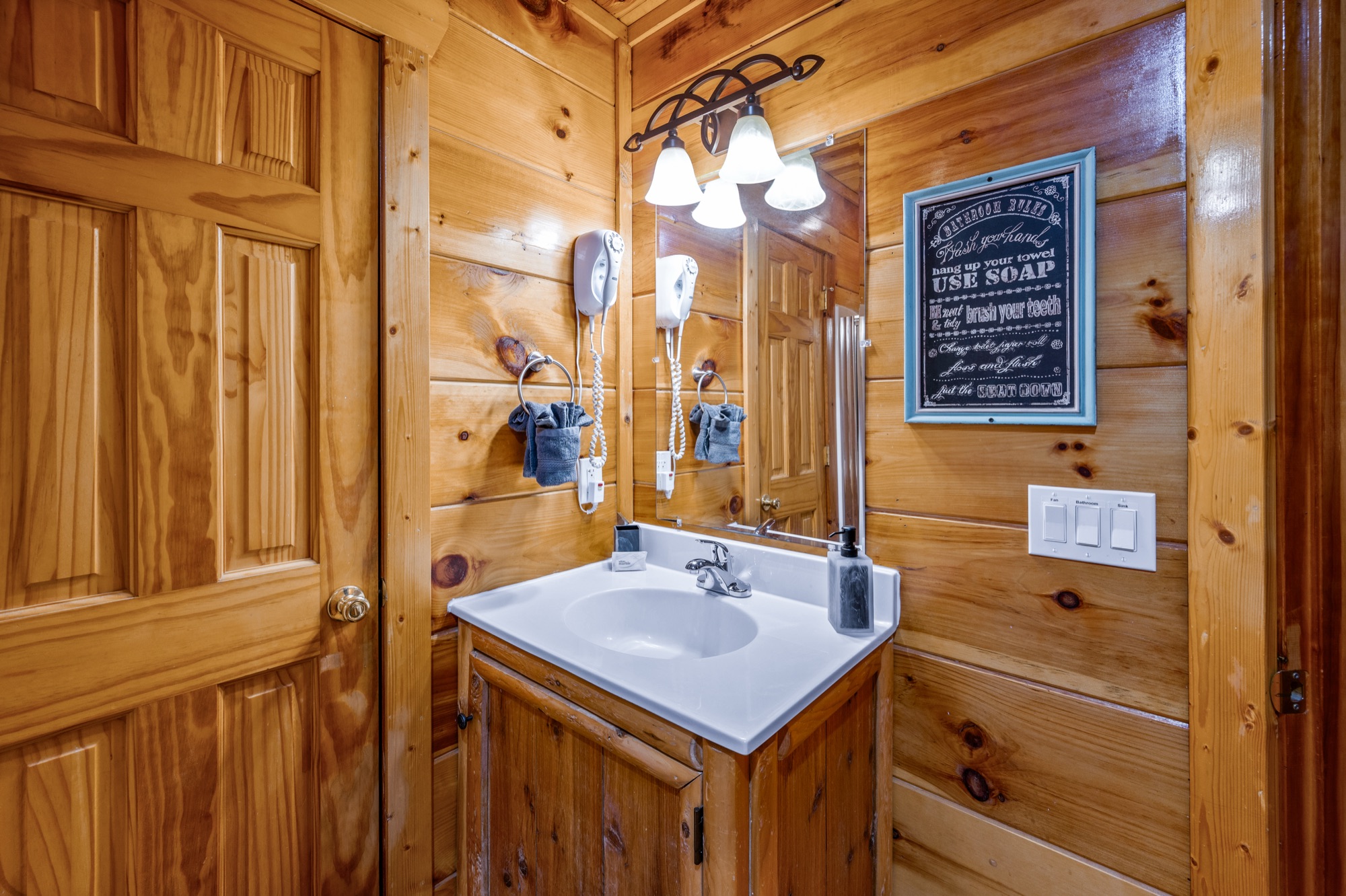 Primary bathroom vanity at Bearadise beneath a Bathroom Rules chalkboard sign